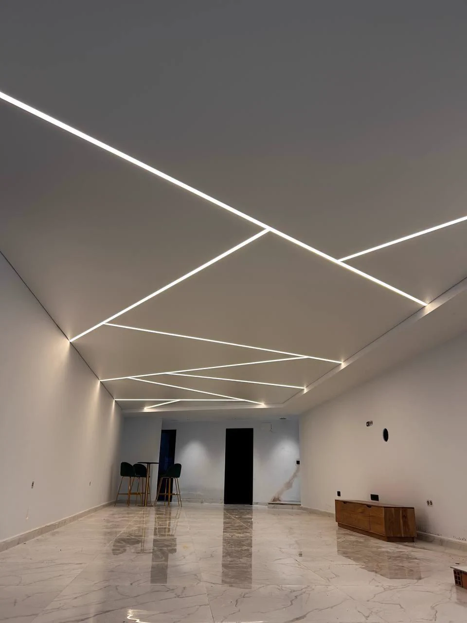 Wohnraum mit Spanndecke und geometrischem LED-Lichtdesign